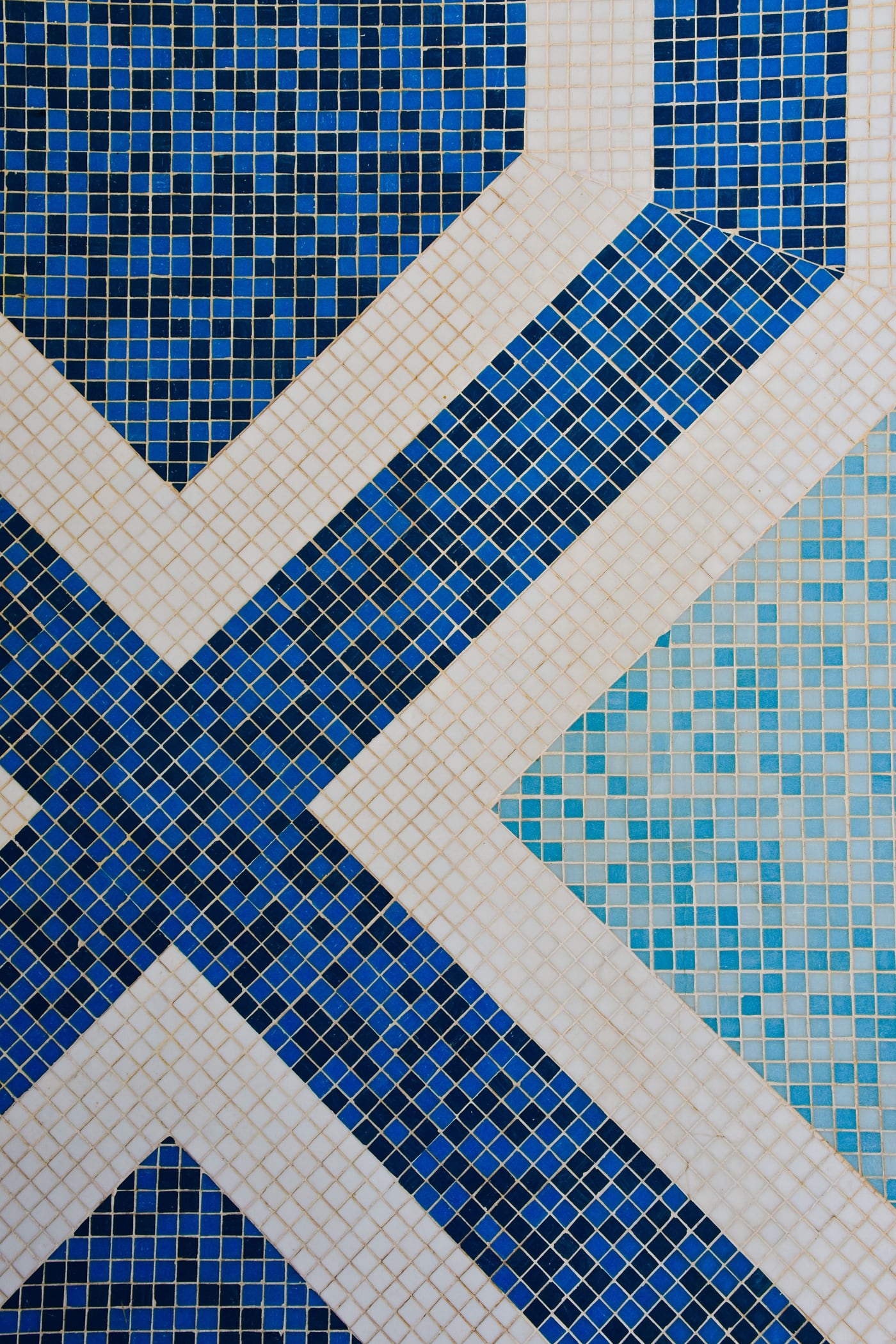 Vom Fliesenleger gesetztes geometrisches Mosaikmuster in Blautönen als Detailansicht